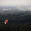 jezsik > A Buddhist flag flies above the countryside.